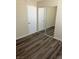 Bright bedroom boasts updated wood-look flooring and a mirrored closet enhancing the room's appeal at 1809 Lamplighter Ln, Las Vegas, NV 89104
