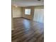 Inviting living room featuring new wood flooring and bright natural light through sliding glass door and window at 1809 Lamplighter Ln, Las Vegas, NV 89104