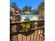 Community pool area with lounge chairs and umbrellas, framed by wrought iron fence and lush greenery at 1908 Rio Canyon Ct # 105, Las Vegas, NV 89128