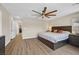 Primary bedroom with wood-look floors and king bed; hallway and laundry room in view at 2084 Airy Petals Walk, Henderson, NV 89044