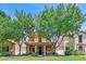 Charming two-story home featuring a welcoming porch, well-manicured lawn, and mature trees at 2084 Airy Petals Walk, Henderson, NV 89044