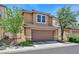 Two-car garage with a brown door, set in a stucco home with a tiled roof at 2084 Airy Petals Walk, Henderson, NV 89044