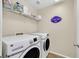 Bright laundry room with white washer, dryer, wire shelving and cute decor at 2084 Airy Petals Walk, Henderson, NV 89044