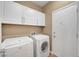 Laundry room with front load washer and dryer and built in cabinets at 2217 Merrimack Valley Ave, Henderson, NV 89044