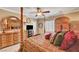 Bedroom boasts four-poster bed, hardwood furniture, carpet floors, a ceiling fan, and shuttered windows at 2217 Merrimack Valley Ave, Henderson, NV 89044