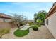 Landscaped backyard with artificial turf, desert landscaping, and manicured bushes at 2766 Mintlaw Ave, Henderson, NV 89044
