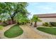 Spacious backyard with lush landscaping, featuring artificial turf and mature trees, creating a serene oasis at 2766 Mintlaw Ave, Henderson, NV 89044