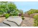 Tranquil backyard with tiered concrete seating, low-maintenance landscaping, and mature trees for privacy at 2766 Mintlaw Ave, Henderson, NV 89044