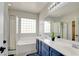 Bathroom with dual sinks, soaking tub, glass-block window, and a separate shower at 2766 Mintlaw Ave, Henderson, NV 89044