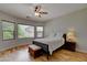Cozy bedroom with a ceiling fan, natural light from large windows, and wood-look flooring at 2766 Mintlaw Ave, Henderson, NV 89044