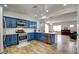 Open concept kitchen features custom blue cabinets, stainless appliances, and bright lighting at 2766 Mintlaw Ave, Henderson, NV 89044