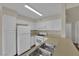 Well-lit kitchen featuring white appliances, ample cabinets, and a double sink for convenience at 3182 Tarpon Dr # 204, Las Vegas, NV 89120