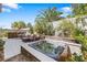 Backyard oasis with a hot tub, outdoor dining set, and lush landscaping at 3257 Rushing Waters Pl, Las Vegas, NV 89135