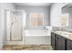Bright bathroom featuring a glass enclosed shower, soaking tub, and modern vanity for a relaxing experience at 3257 Rushing Waters Pl, Las Vegas, NV 89135