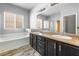 Bright bathroom featuring a soaking tub, dual vanities, and a separate shower at 3257 Rushing Waters Pl, Las Vegas, NV 89135