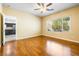 A bright bedroom featuring hardwood floors, a window, and an entryway to the kitchen and bathroom at 3257 Rushing Waters Pl, Las Vegas, NV 89135
