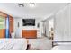 Bright bedroom featuring wood paneling, a dresser with a TV, and a mirrored closet at 3499 Middlebury Ave, Las Vegas, NV 89121