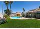 Backyard oasis with a refreshing pool, covered patio, lush lawn, and mature trees at 5025 Chambliss Dr, Las Vegas, NV 89130