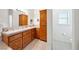 Well-lit bathroom with a vanity, oak cabinetry, neutral countertops, and tiled floors, offering functionality and storage at 5060 Wheatland Dr, Pahrump, NV 89061