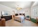 Cozy bedroom with neutral carpet, ceiling fan, and large window providing ample natural light, creating a relaxing atmosphere at 5060 Wheatland Dr, Pahrump, NV 89061