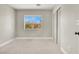 Bedroom featuring neutral carpet, paint and baseboards; window with sunny view at 5200 Paradise Skies Ave, Las Vegas, NV 89156