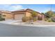 Single-story home with a tan exterior, low-maintenance landscaping, and a two-car garage at 6061 Moonlight Sonata Ave, Las Vegas, NV 89122