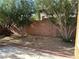Cozy backyard area with rock groundcover, trees, and a brick wall at , Las Vegas, NV 89178