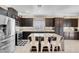 Stylish kitchen features dark wood cabinets, stainless appliances, granite counters, and a central island with bar stools at 10135 Haymarket Peak Ave, Las Vegas, NV 89166