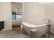 A serene bathroom offers a modern freestanding tub with views of a contemporary bedroom at 11660 Summit Club Dr # 204, Las Vegas, NV 89135