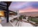 The stunning exterior features multiple balconies with glass railings overlooking the desert landscape and vibrant sunset at 11660 Summit Club Dr # 204, Las Vegas, NV 89135