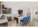 The modern kitchen has an island with bar stool seating and a convenient stainless steel sink at 11676 Midnight Melody Ave, Las Vegas, NV 89138