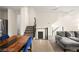 A modern living room with open stairs, comfortable gray sofa and a wood table with blue chairs offers a welcoming space at 11676 Midnight Melody Ave, Las Vegas, NV 89138