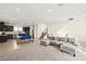 The open-concept living room and kitchen, features modern stairs and comfortable gray sofa, perfect for entertaining at 11676 Midnight Melody Ave, Las Vegas, NV 89138