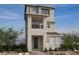 Modern three-story home featuring a balcony, unique architectural design, and desert landscaping at 1529 Little Penguin St, Las Vegas, NV 89138