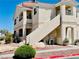 A tan condo building with exterior staircases, desert landscaping, and a well-manicured shrub at 1881 W Alexander Rd # 2117, North Las Vegas, NV 89032