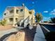 A tan two-story condo building features well-maintained landscaping and an inviting entrance at 1881 W Alexander Rd # 2117, North Las Vegas, NV 89032