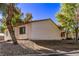 Exterior view of a well-maintained stucco home with mature trees and a landscaped yard at 1911 Hobson Dr, Henderson, NV 89074