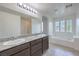 Bathroom featuring a double vanity, soaking tub, and bright natural light at 2300 Sky Island Dr, Henderson, NV 89002