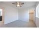 Bright bedroom features neutral paint, carpet, ceiling fan, and a walk in closet, offering a simple design at 2300 Sky Island Dr, Henderson, NV 89002