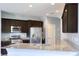 Modern kitchen featuring granite countertops, stainless steel appliances, and dark wood cabinets at 2300 Sky Island Dr, Henderson, NV 89002
