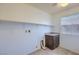 Well-lit laundry room features connections, upper shelving and a granite counter on the dark wood cabinet at 2300 Sky Island Dr, Henderson, NV 89002
