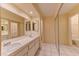 Well-lit bathroom featuring a double sink vanity with tile flooring, and mirrors above each sink at 2352 Pickwick Dr # 85, Henderson, NV 89014