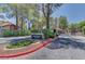 Gated entry of The Village Green community, featuring lush landscaping and mature trees at 2352 Pickwick Dr # 85, Henderson, NV 89014