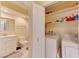Functional laundry room with washer, dryer, shelving, and access to a bathroom with a vanity and toilet at 2352 Pickwick Dr # 85, Henderson, NV 89014