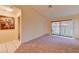 Living room featuring carpet flooring, access to the backyard through sliding doors, and neutral wall paint at 2352 Pickwick Dr # 85, Henderson, NV 89014