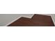 Close-up of rich hardwood flooring with white trim baseboards against a light gray wall at 2405 Esteem Ridge Dr, Henderson, NV 89052