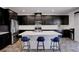 Modern kitchen with stainless steel appliances, dark cabinets, and a quartz countertop island at 242 Polaris Ridge Ave, Henderson, NV 89011