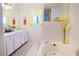 Bright bathroom with a bathtub and a double vanity against a mirrored wall at 2801 Peggy Ave, Pahrump, NV 89048