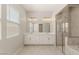 A bright bathroom featuring double sinks, a large mirror, and a glass-enclosed shower at 3391 Stone View Ave, Henderson, NV 89044
