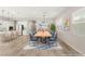 Staged dining room with modern table, chairs, stylish rug, and open view to a sleek, white kitchen at 3391 Stone View Ave, Henderson, NV 89044